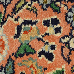 A detailed close-up of the Kirman Persian rug, highlighting its soft, plush texture and intricate floral motifs. The rich peach background contrasts beautifully with navy, green, and ivory accents, showcasing the fine knotting and artistry of traditional Persian weaving.
