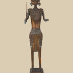 Antique dark brass sculpture of an Indian soldier, possibly tribal, holding a sword and with an open hand, adorned with traditional jewelry and a distinctive headdress, standing on a decorated base.