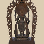 Back view of a dark brass statue of Lord Vishnu, showing the intricate carving of the arch, the deity's form, and the details of his flowing garments and held attributes.