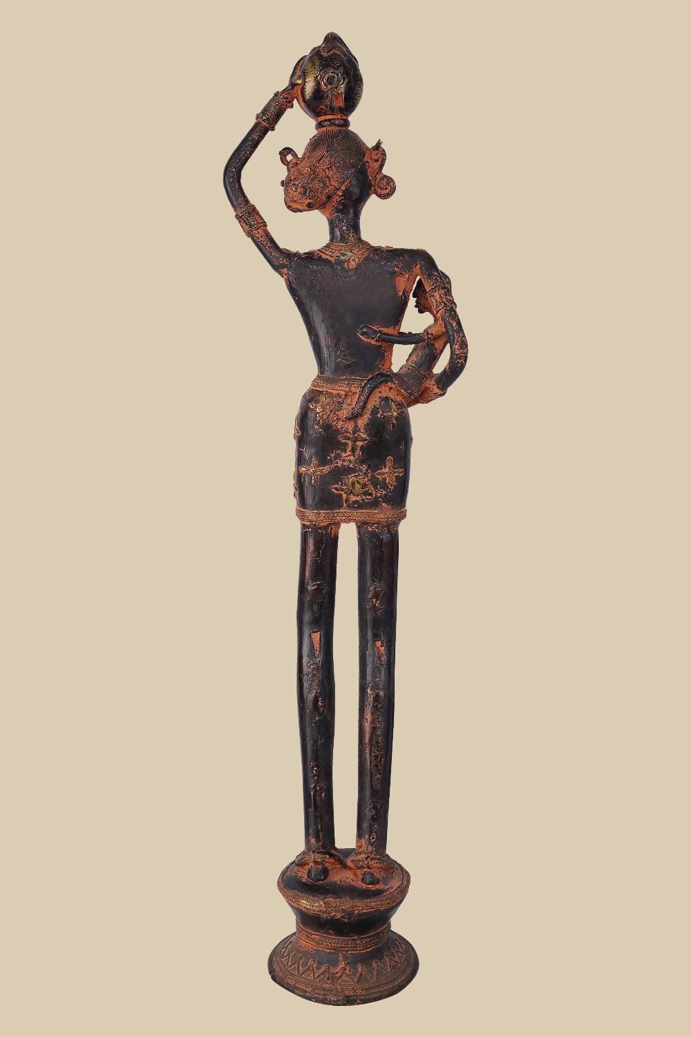 ack view of an antique dark brass sculpture of a village woman carrying a child in her arm and a pot on her head, showing the details of her posture, the child, and the pot's placement. The sculpture stands on a decorated base.