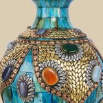 Detailed close-up of an azure Surahi vase made from camel bone, showcasing the intricate patterns of metalwork and colorful gemstone inlays on its surface.