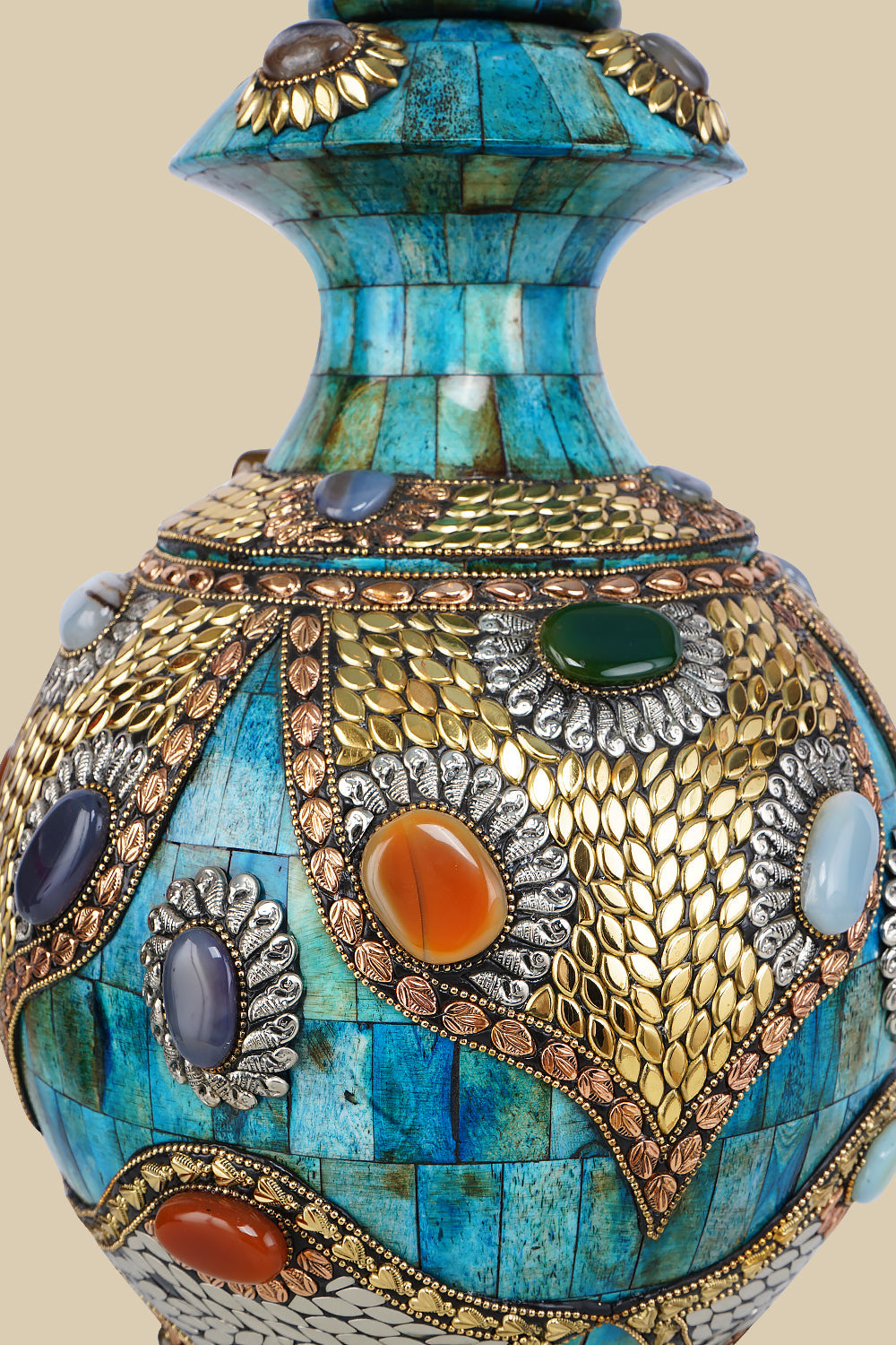 Detailed close-up of an azure Surahi vase made from camel bone, showcasing the intricate patterns of metalwork and colorful gemstone inlays on its surface.