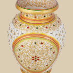 Ornate white marble vase with detailed undercut openwork, hand-painted with golden floral patterns and accented with embedded red and green gemstones.