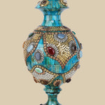 Exquisite azure camel bone vase intricately adorned with gold-colored metalwork and various colorful gemstone inlays, showcasing a traditional Surahi shape.