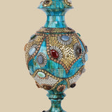 Exquisite azure camel bone vase intricately adorned with gold-colored metalwork and various colorful gemstone inlays, showcasing a traditional Surahi shape.