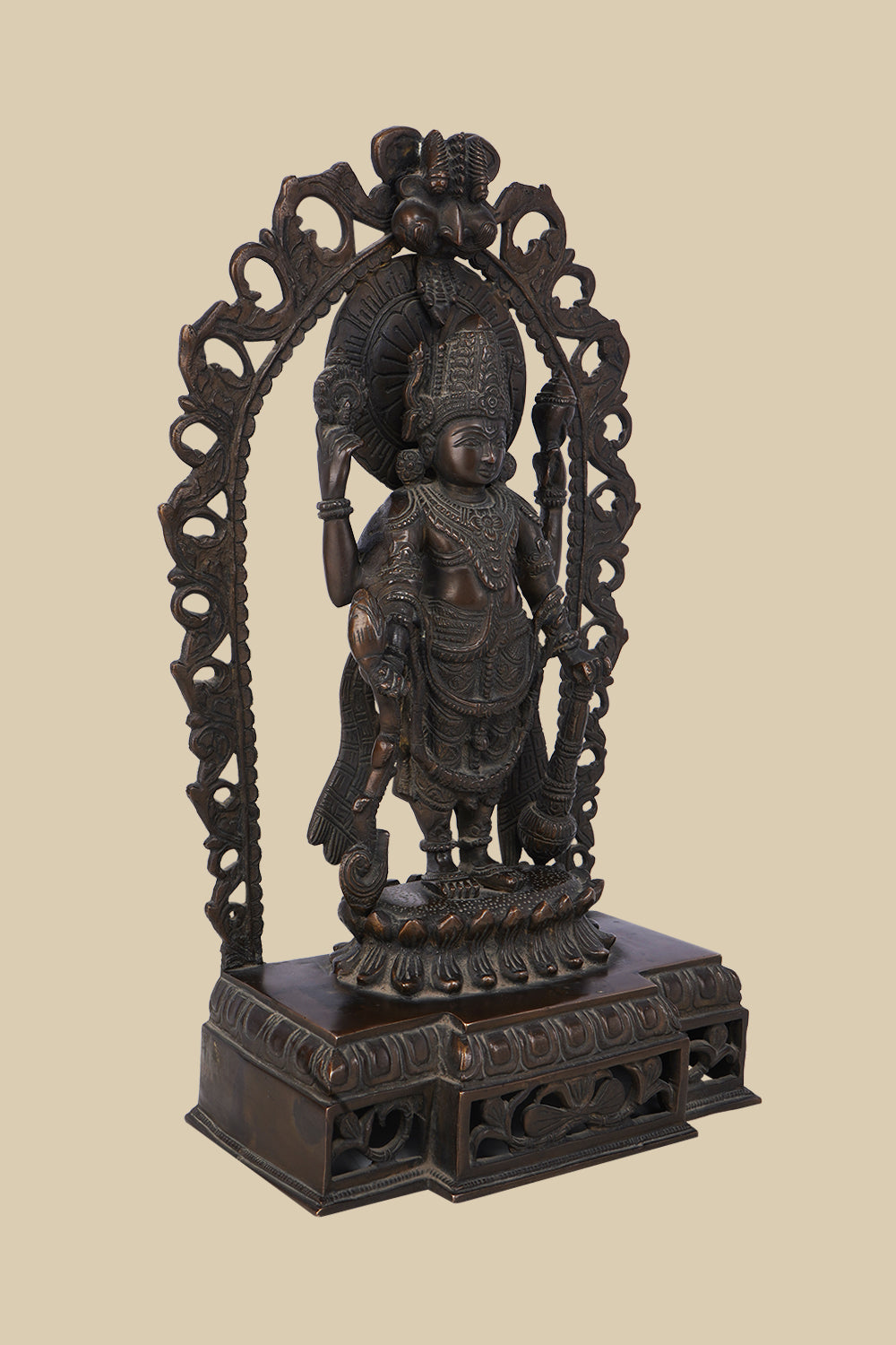 Ornate dark brass statue of Lord Vishnu standing beneath a decorative arch, holding his four symbolic attributes: the conch, discus, lotus, and mace. The intricate carving and traditional design are prominent.