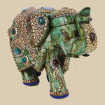 Ornate green camel bone elephant figurine featuring intricate gold-colored metalwork and various semi-precious stone embellishments.