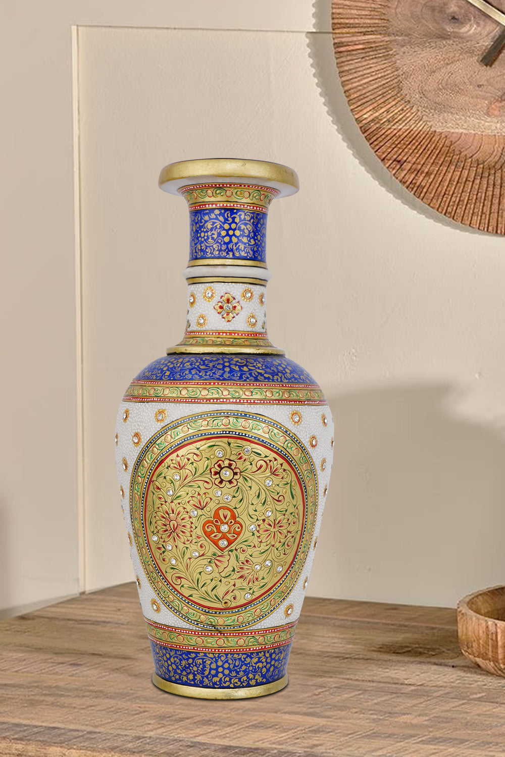 Ornate white marble flower vase meticulously hand-painted with traditional Indian motifs in vibrant blue, red, and green, highlighted with gold accents and small embedded gemstones.