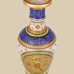 White marble vase with a vibrant hand-painted design featuring intricate floral patterns in rich blues, reds, and greens, accented with gold detailing and small embedded stones. The view is from slightly above, showing the painted interior of the rim.