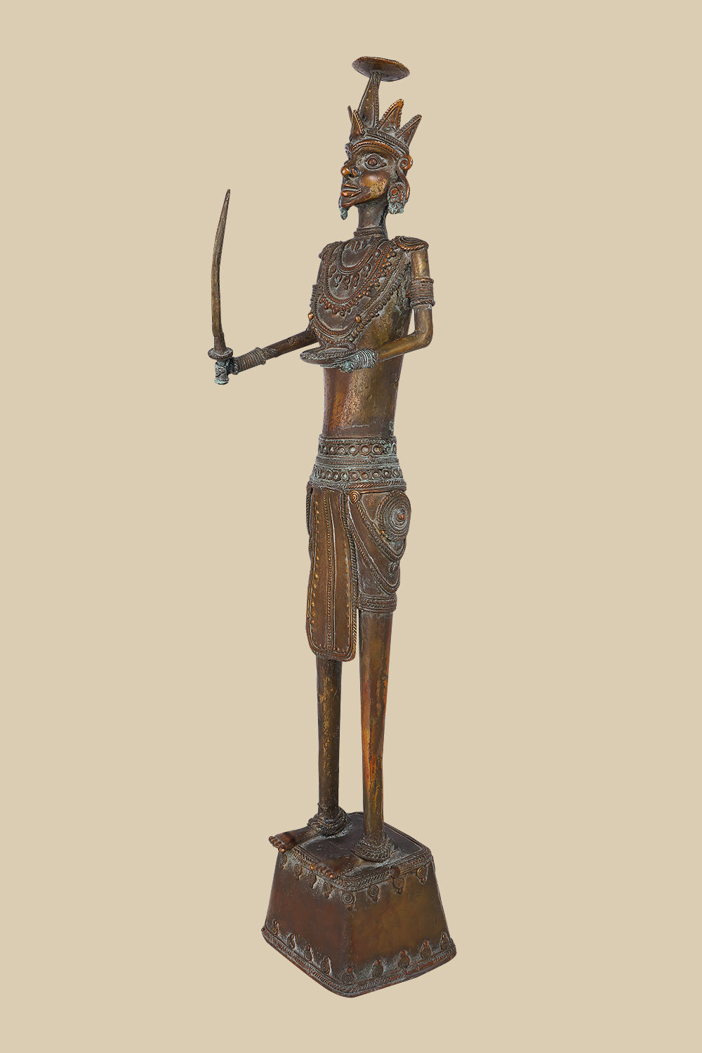 Vintage-style dark brass sculpture of a warrior holding a curved sword and with an open palm, adorned with traditional attire and a unique headdress, standing on a decorated platform.